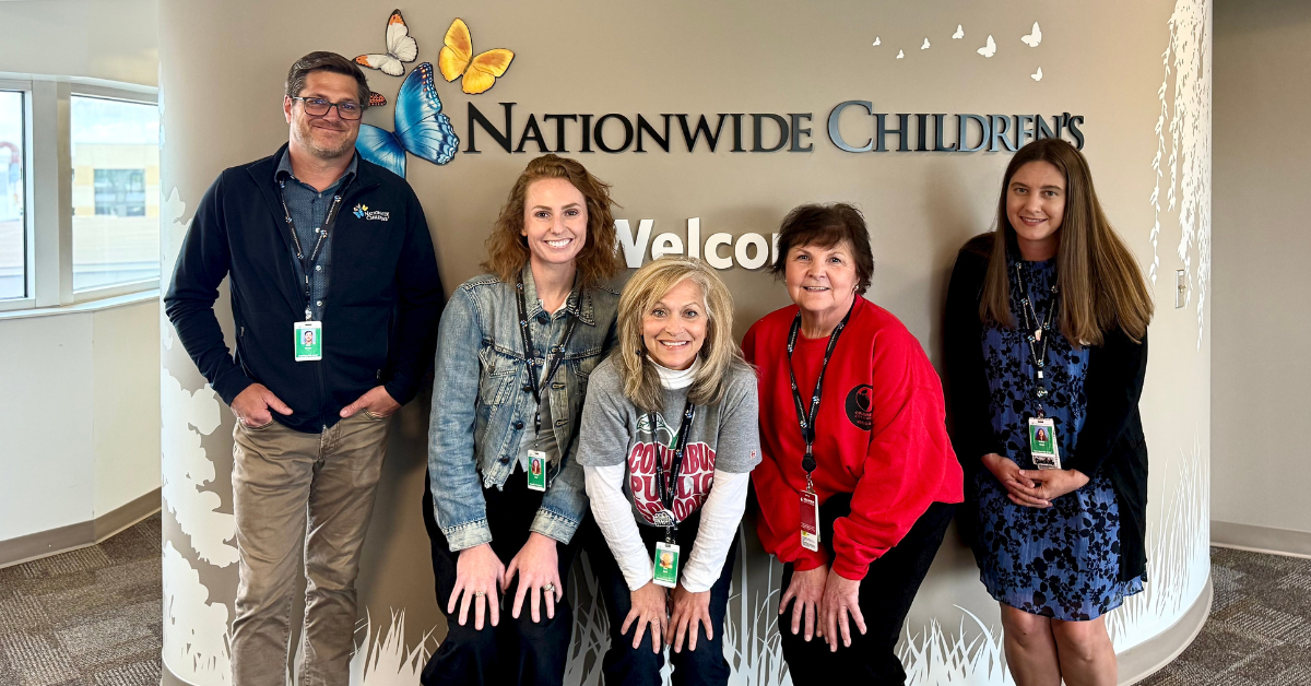 teachers standing in front of sign that reads natiowide childrens